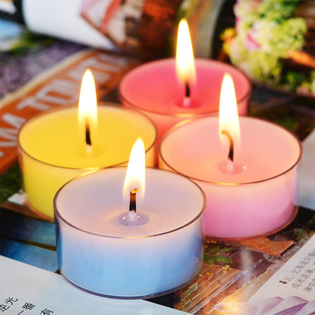 Four lit candles in different colors on a surface with background