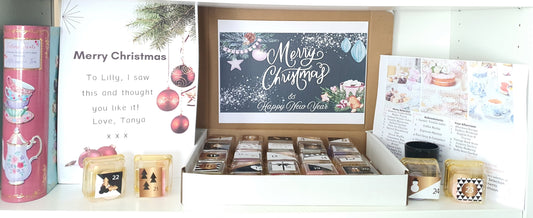 Tea light candle box set with Christmas-themed cards and tea lights on a white surface.