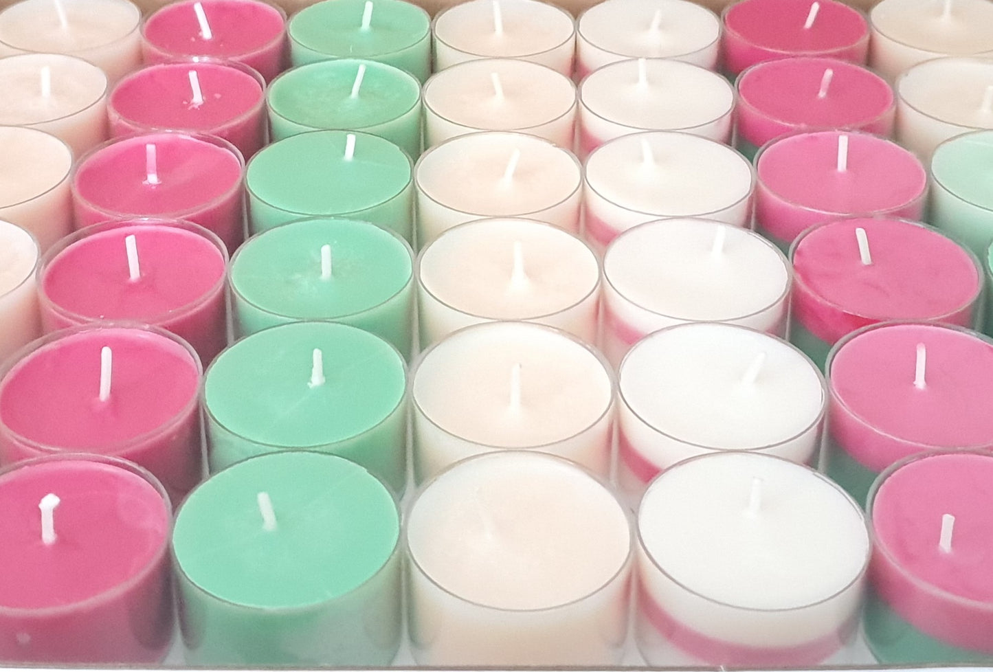 Assorted small candles in pink, green, and white 