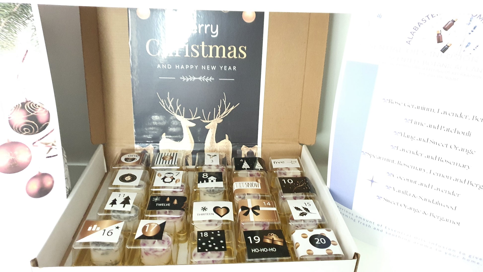 Box of Christmas candles  with a 'Merry Christmas' card in the background
