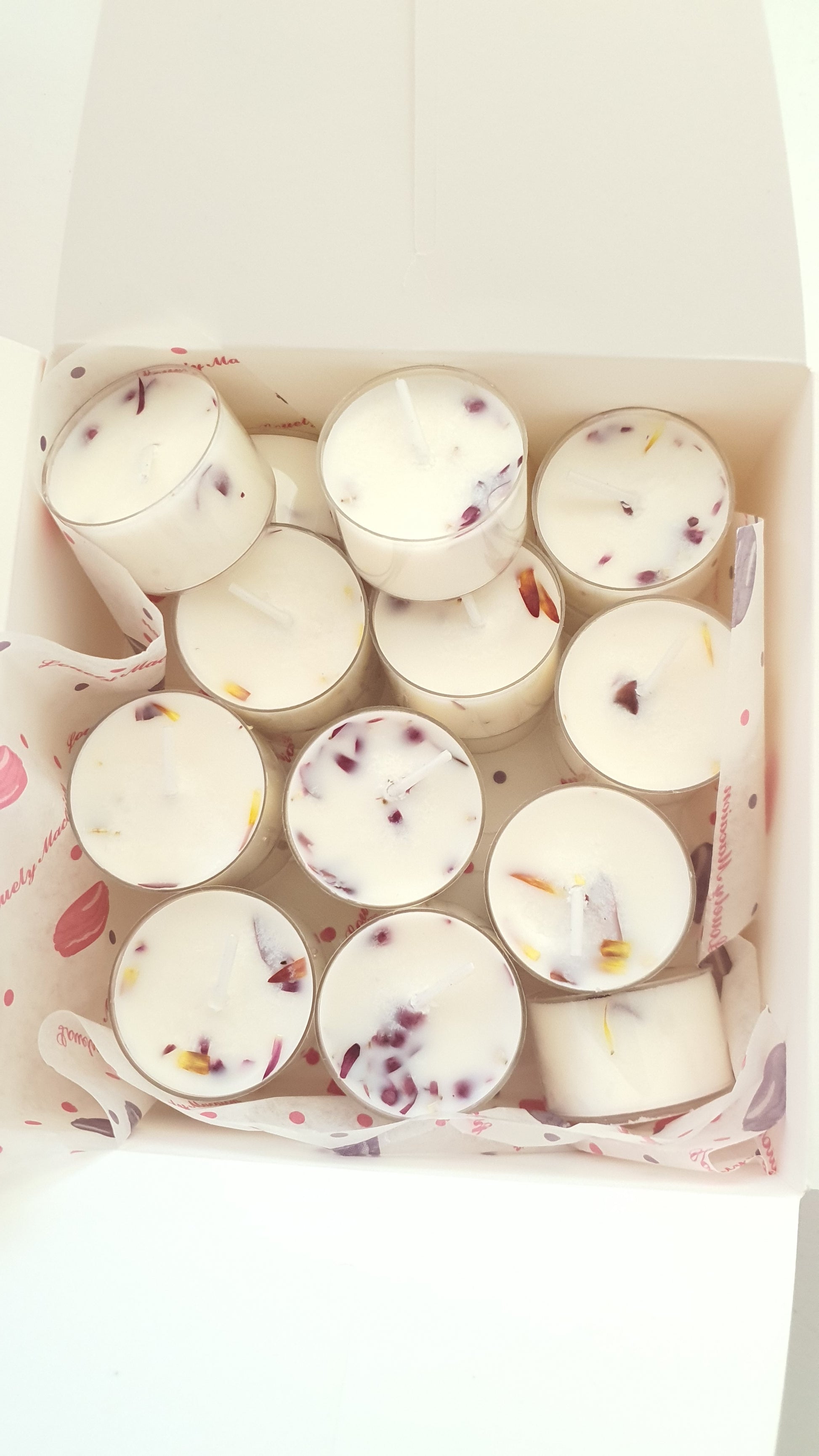 Box of small candles with decorative elements on a white background