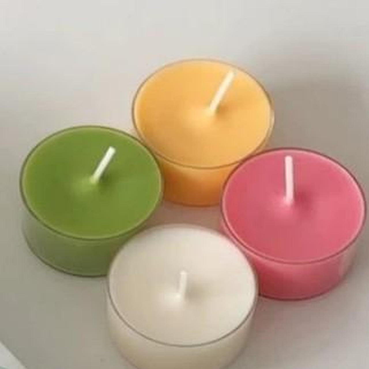 Four colorful candles on a white surface